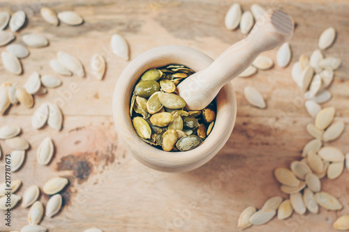 A wooden mortar full of seeds for grinding