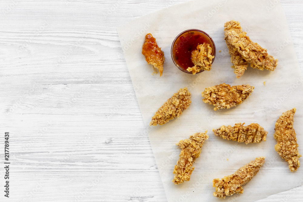 Overhead view, fried chicken strips with sauce on white wooden surface. Flat lay, from above, top view. Copy space and text area. Overhead view, fried chicken strips with sauce on white wooden surface. Flat lay, from above, top view. Copy space and text area.