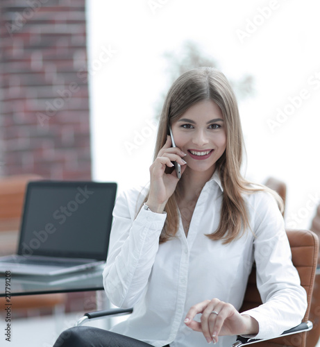 business woman talking on mobile phone sitting in the office