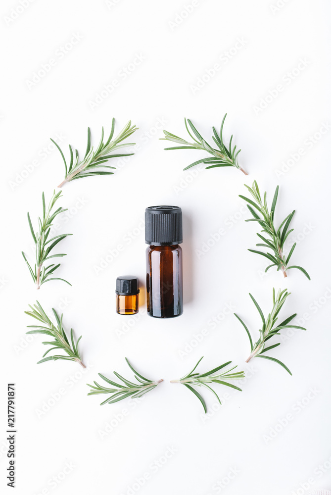 essential oils with botles and herbs on white background essential oils with botles and herbs on white background