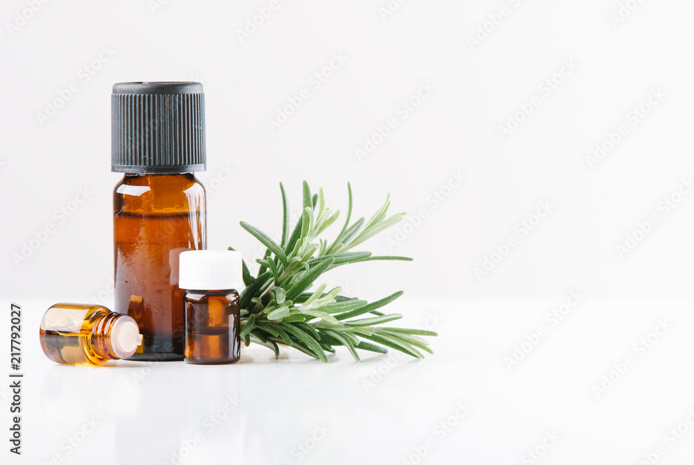 essential oils with botles and herbs on white background essential oils with botles and herbs on white background