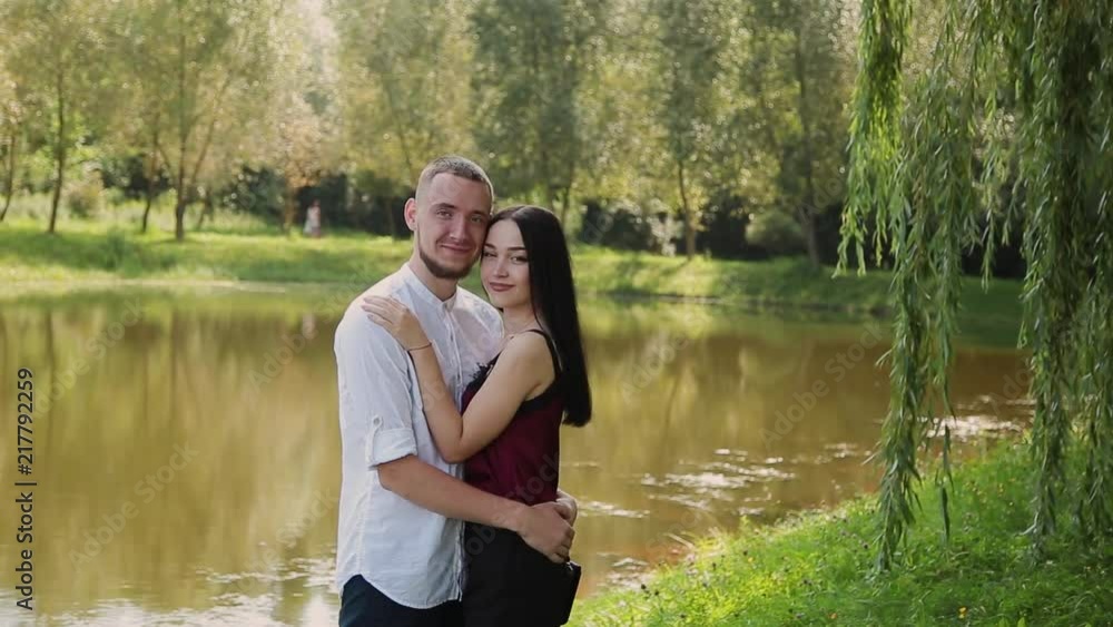Lovers stand on the shore of the lake talking embrace and kiss. Lovers stand on the shore of the lake talking embrace and kiss.