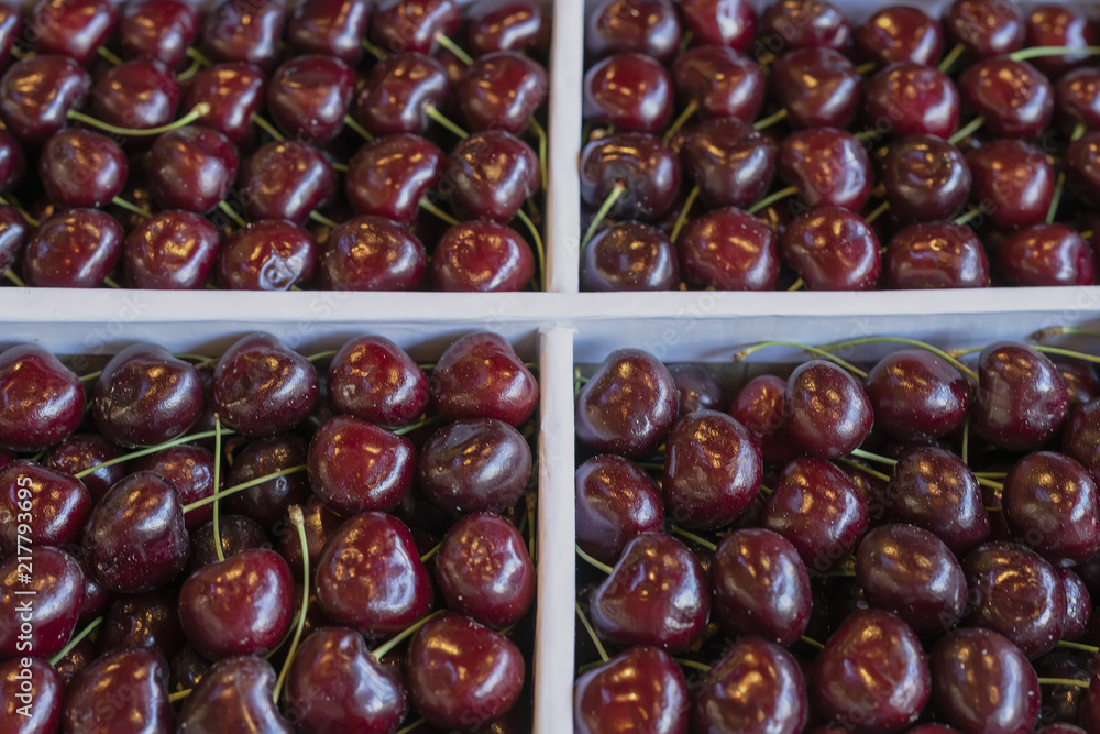 Fresh cherry, not very clean in four trays of the fruit market Fresh cherry, not very clean in four trays of the fruit market