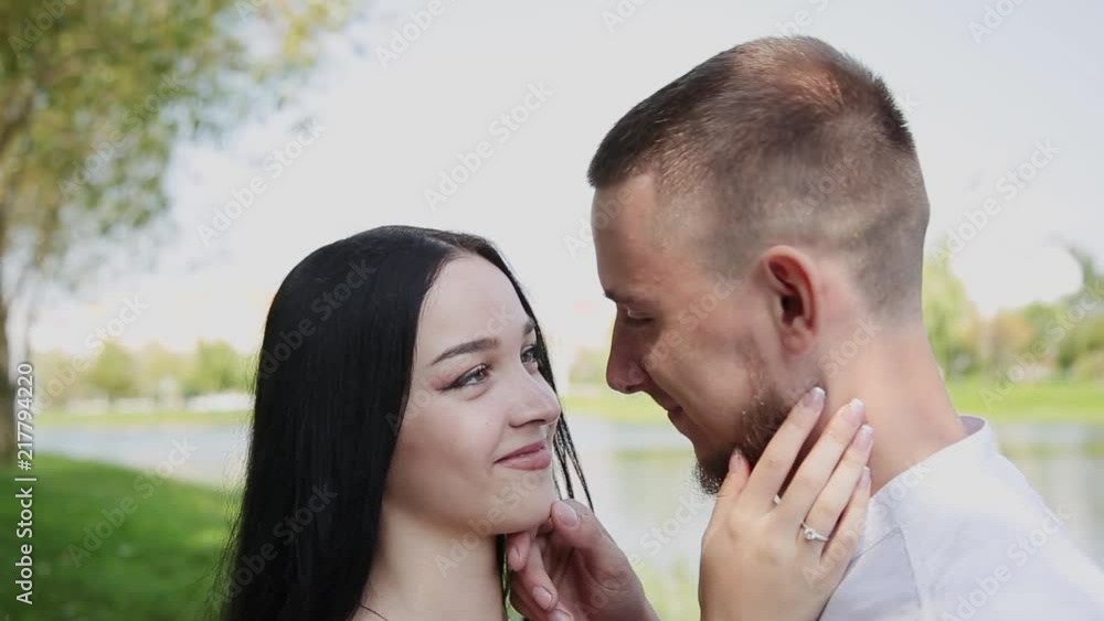 Lovers stand on the shore of the lake talking embrace and kiss. Lovers stand on the shore of the lake talking embrace and kiss.