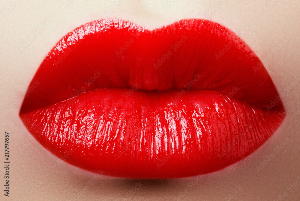 Obraz premium Cosmetics, makeup and trends. Bright lipstick on lips. Closeup of beauty female mouth with red lip makeup. Beautiful part of female face. Perfect clean skin