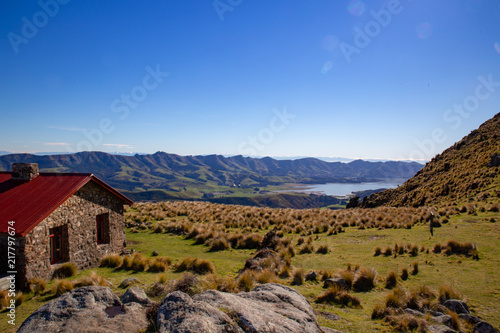 Hiking in New Zealand on Packhorse Track is the historic stone hut on the ridge overlooking the valleys down below
