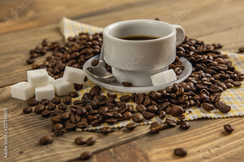 Taza de café con azúcar y granos de café tostados