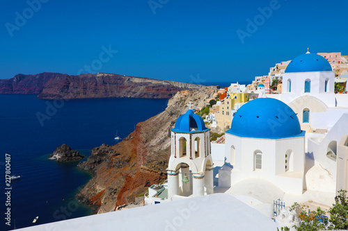 Stunning panoramic view of Santorini island with white houses and blue domes on famous Greek resort Oia, Greece, Europe. Traveling concept background. 