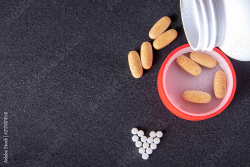 oval brown pills in a red cap on a dark blue background