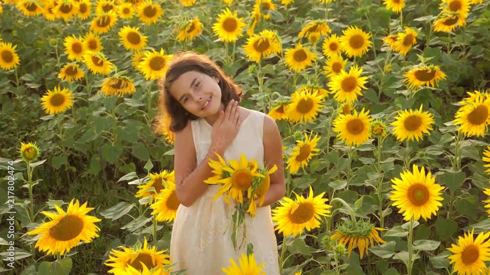 Happy little girl on the field of sunflowers in lifestyle summer. beautiful little girl in sunflowers. slow motion video. girl teenager and sunflowers field concept agriculture Happy little girl on the field of sunflowers in lifestyle summer. beautiful little girl in sunflowers. slow motion video. girl teenager and sunflowers field concept agriculture