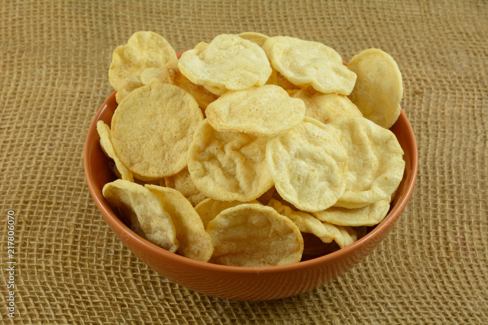 Healthy crispy hummus chips alternative in orange bowl on burlap Healthy crispy hummus chips alternative in orange bowl on burlap