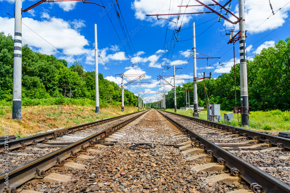 View on a railroad track and white clouds in blue sky View on a railroad track and white clouds in blue sky