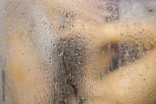 Beautiful woman in the shower behind glass with drops © Brastock Images