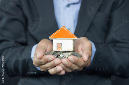 House models and coin in human hands, Mortgage concept by money house from the coins.