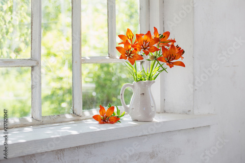 Fototapeta Naklejka Na Ścianę i Meble -  orange lily on windowsill