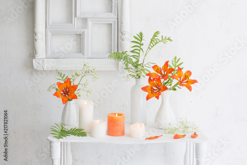 forange flowers and candles on white background photo