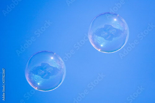 Soap bubbles in flight against the blue sky