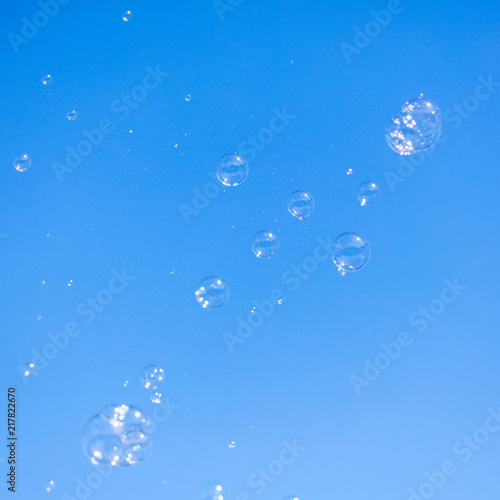 Soap bubbles in flight against the blue sky