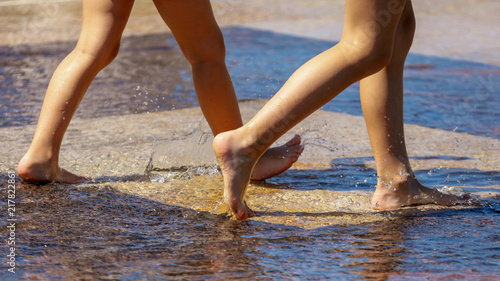The legs of a girl in the water in a fountain © schankz