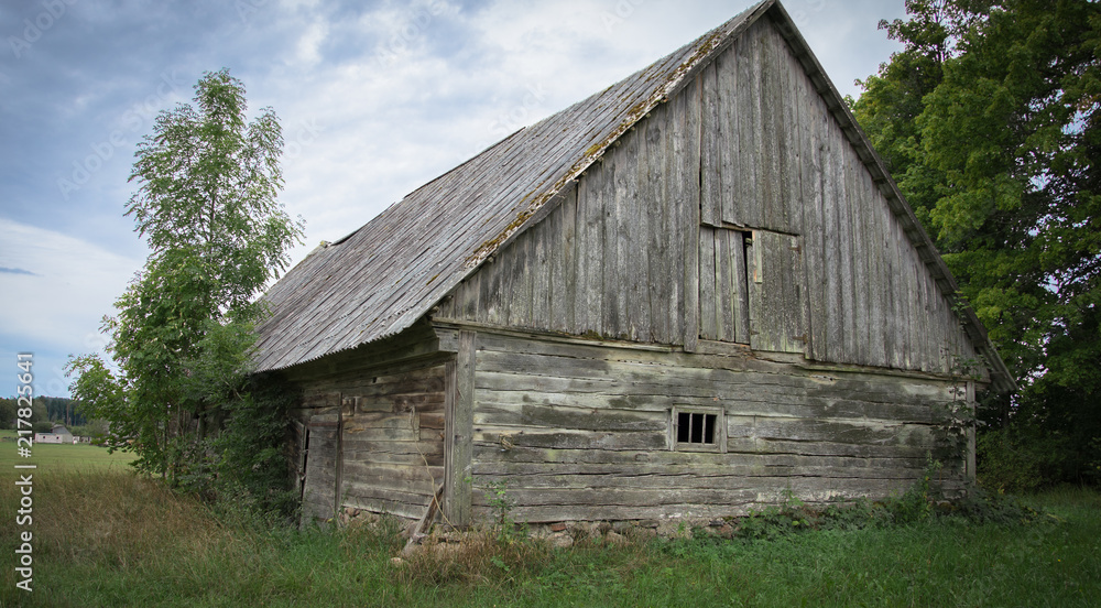 An old abandoned wooden shed with a roof of slate in the village. An old abandoned wooden shed with a roof of slate in the village.