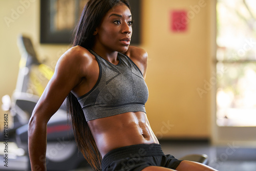 fit african american woman working out and stretching in gym