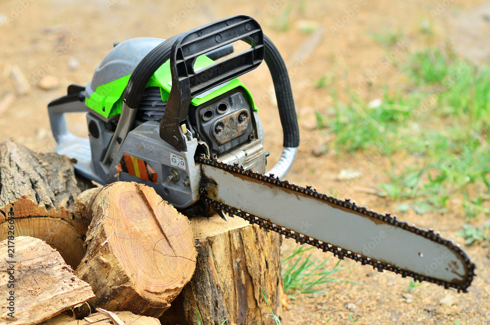The working chainsaw lies on the stump