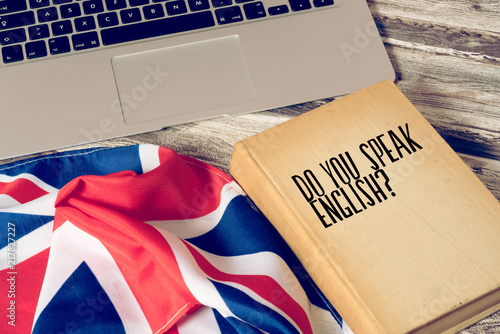 Ein Computer, Flagge von Großbritannien und Buch mit dem Titel Sprechen Sie englisch