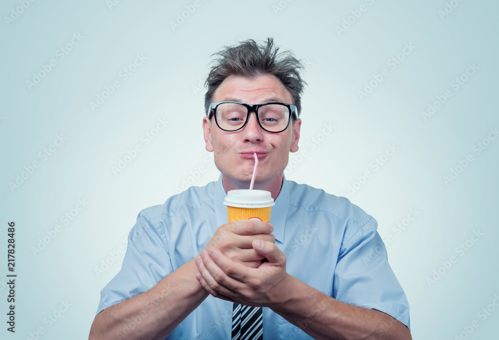 Fototapeta premium Happy man in glasses drinking from a paper cup with a straw, eyes closed with pleasure