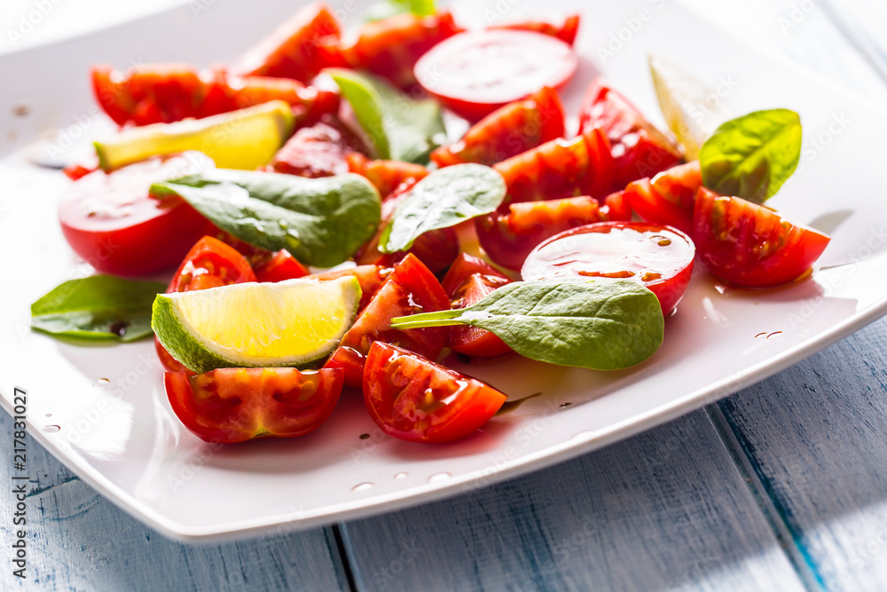 Tasty tomatoes salad with lime spinach leaves and balsamic sauce