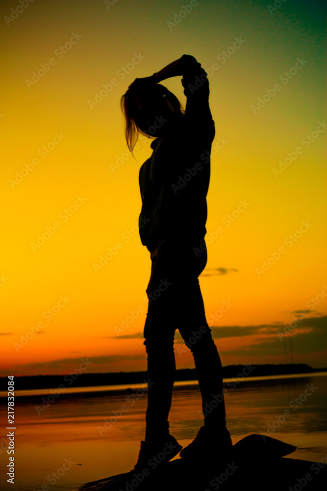 Silhouette of young woman at sunset