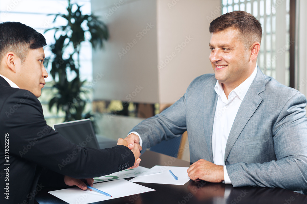 two business partners sitting at a table together and working. two business partners sitting at a table together and working.