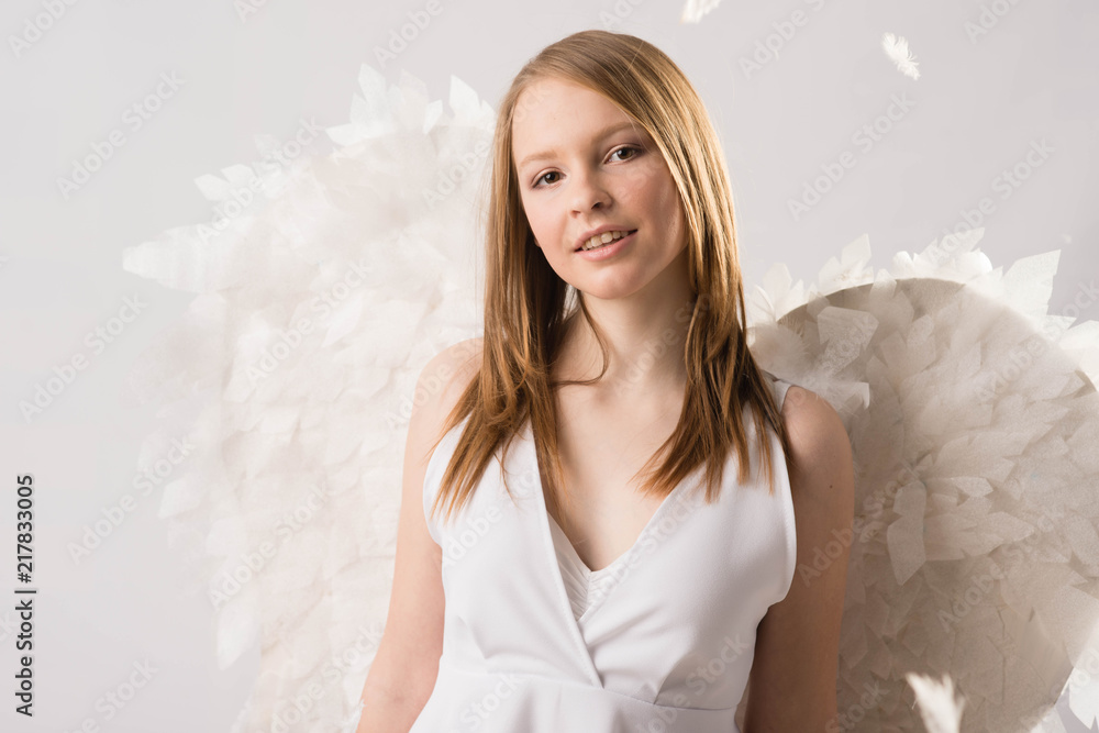 blonde girl in white with angel wings stands blonde girl in white with angel wings stands