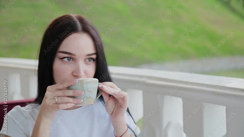 A very pretty girl drinks cappuccino on the restaurant's open terrace. A very pretty girl drinks cappuccino on the restaurant's open terrace.