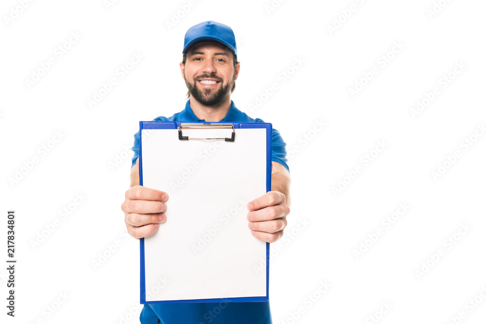handsome young delivery man holding blank clipboard and smiling at camera isolated on white handsome young delivery man holding blank clipboard and smiling at camera isolated on white