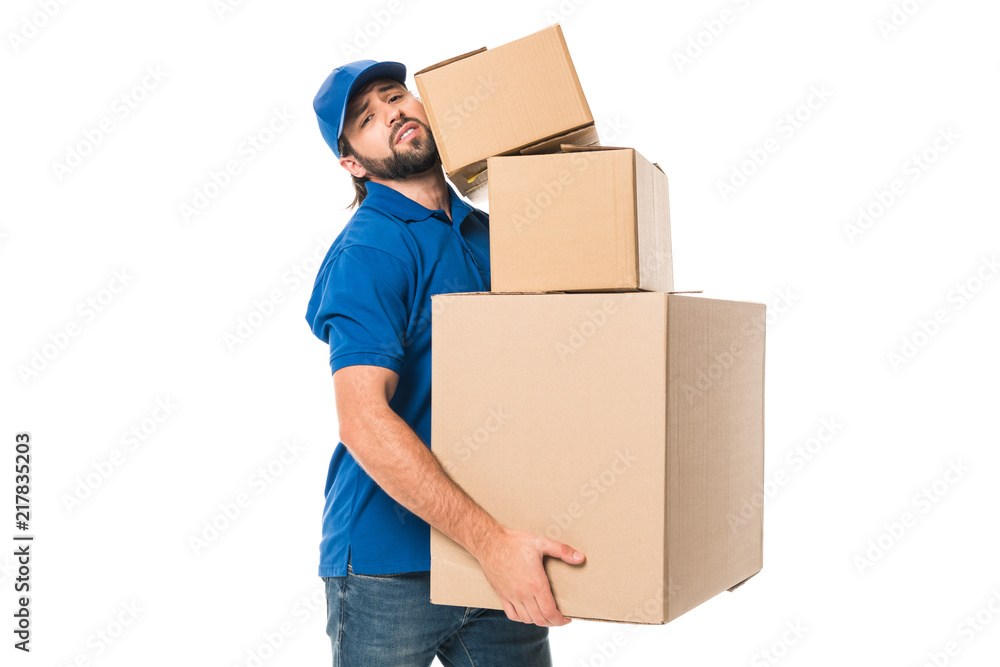 tired delivery man holding stacked cardboard boxes and looking at camera isolated on white tired delivery man holding stacked cardboard boxes and looking at camera isolated on white