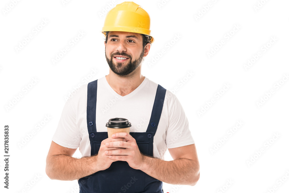 handsome smiling workman in hard hat holding coffee to go and looking away isolated on white handsome smiling workman in hard hat holding coffee to go and looking away isolated on white