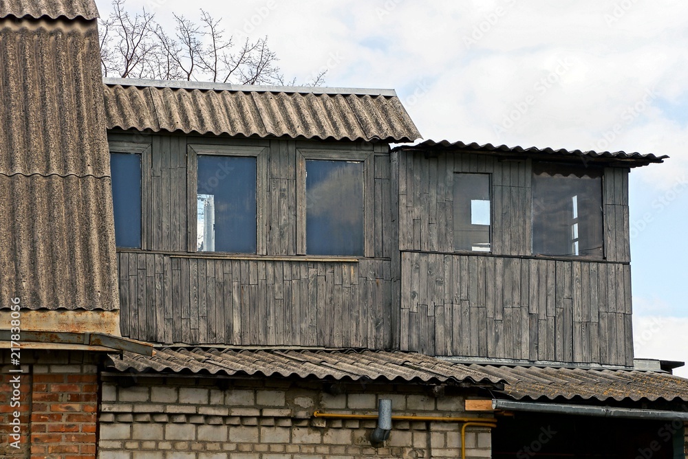 part of an old house with a gray wooden loft and windows part of an old house with a gray wooden loft and windows