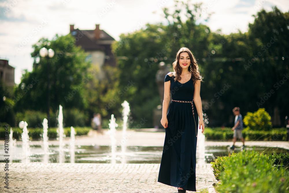 A girl is walking around the city, near a large fountain. Sunny day. Summer A girl is walking around the city, near a large fountain. Sunny day. Summer