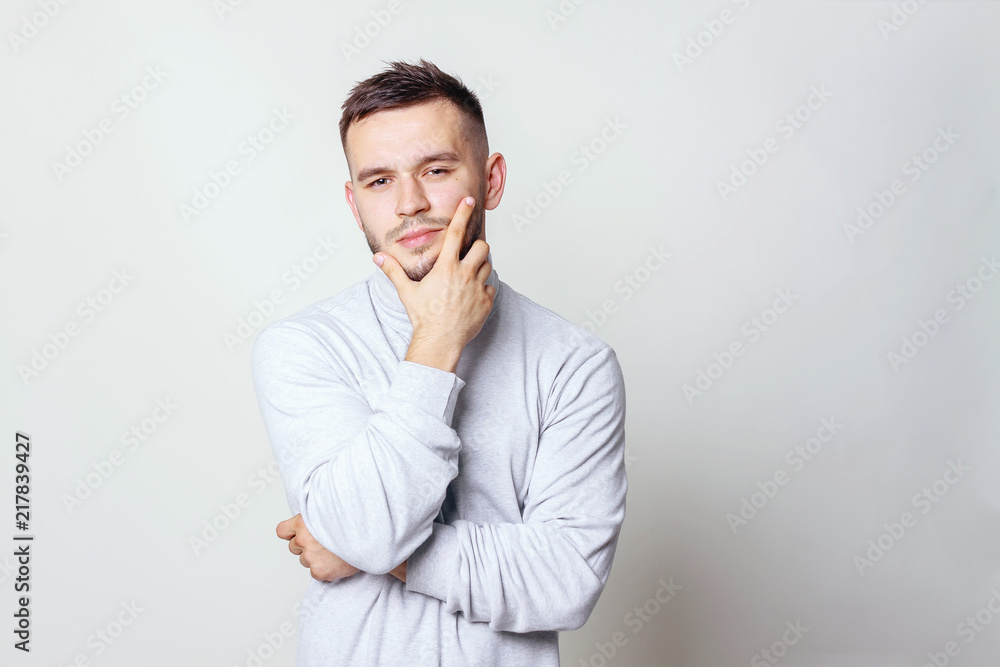 Portrait of a handsome young man thinking on something, isolated on gray background Portrait of a handsome young man thinking on something, isolated on gray background