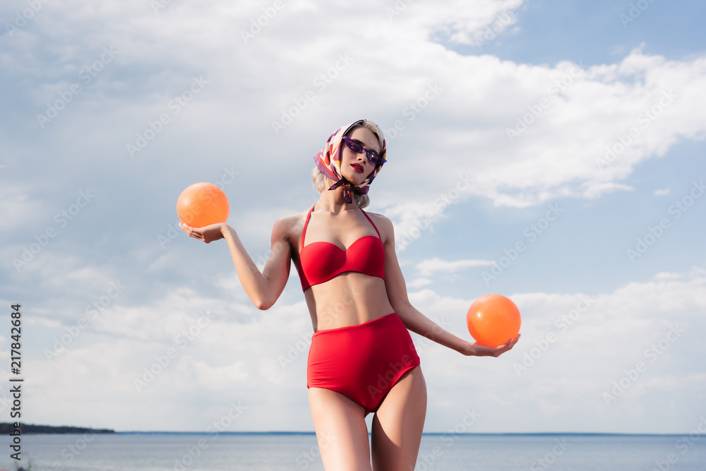 attractive elegant girl in vintage bikini and silk scarf posing with balls  at sea foto de Stock | Adobe Stock