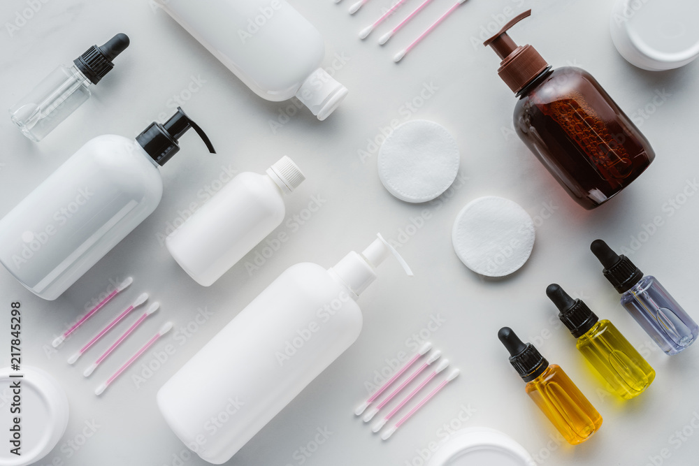 flat lay with bottles of cream, natural oils and cosmetic pads on white surface, beauty concept flat lay with bottles of cream, natural oils and cosmetic pads on white surface, beauty concept