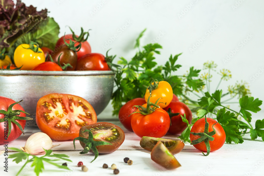Fresh tomatoes and parsley, dill, garlic on a light background in a rustic kitchen and wooden utensils still life with a copy space Fresh tomatoes and parsley, dill, garlic on a light background in a rustic kitchen and wooden utensils still life with a copy space