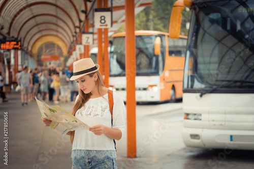 Obraz na płótnie Traveler girl is waiting for a bus at the bus station. Trip to Europe. Travel and active lifestyle concept. w salonie