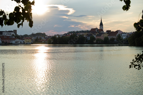 Czech republic, Jindrichuv Hradec - August 8, 2018: Vajgar pond during sunset. City centre in tha background.  photo