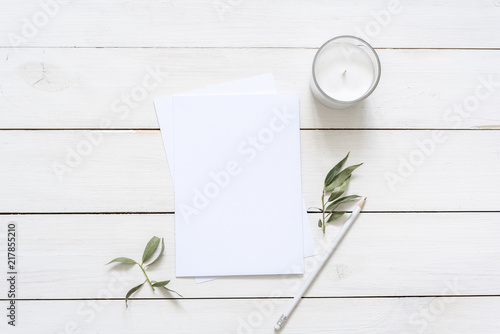 Modern flat lay with card blank space, stationary, candle, leaves, white pencil. Ready for you to insert your text, invitation, wedding or logo. Best for social media, backgrounds, blogs