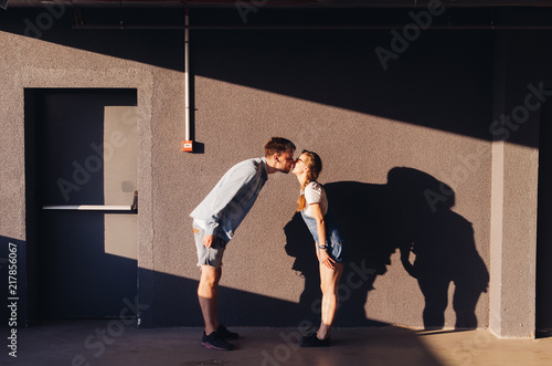 Kissing couple standing near parking wall photo