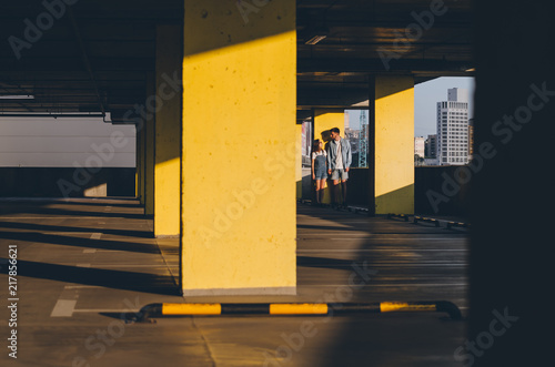 Couple holding hands standing near parking wall photo