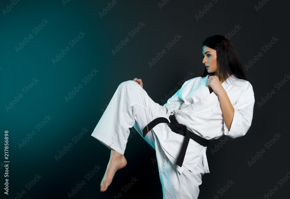 Sporty karate,taekwondo and kyokushin woman in white kimono with black belt  on dark background. Sport concept with copy space. foto de Stock | Adobe  Stock