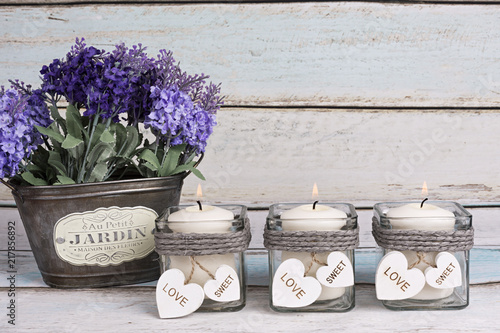 Fototapeta Naklejka Na Ścianę i Meble -  Flores de lavanda en macetero vintage y velas encendidas.