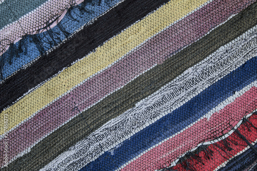Traditional rustic carpet with a striped pattern. Background of multi-colored homespun rug. 